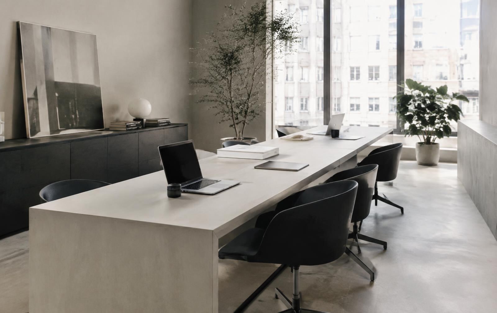 Bright minimalist office with long desk and laptops